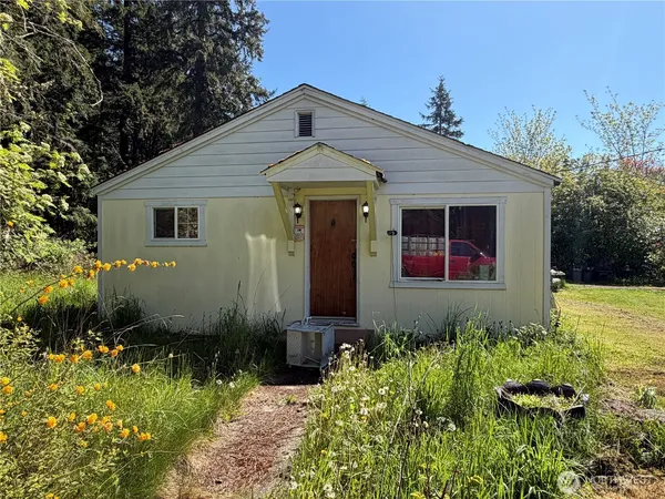 a front view of house with yard and trees around
