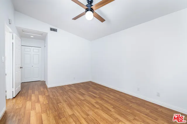a view of room with wooden floor and ceiling fan