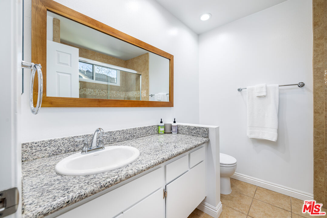29202 Heathercliff Road Malibu, CA 90265 - Photo 16 of 20 a bathroom with a granite countertop sink and a mirror