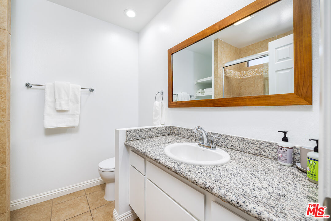 29202 Heathercliff Road Malibu, CA 90265 - Photo 17 of 20 a bathroom with a granite countertop sink and a toilet