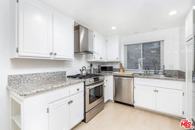 a kitchen with stainless steel appliances granite countertop a sink stove and cabinets