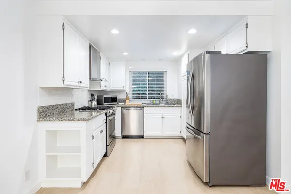 a kitchen with a refrigerator a sink and cabinets