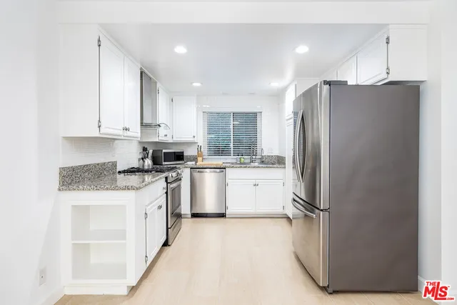a kitchen with a refrigerator a sink and cabinets