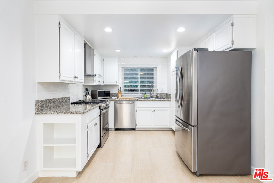 29202 Heathercliff Road Malibu, CA 90265 - Photo 8 of 20 a kitchen with a refrigerator a sink and cabinets