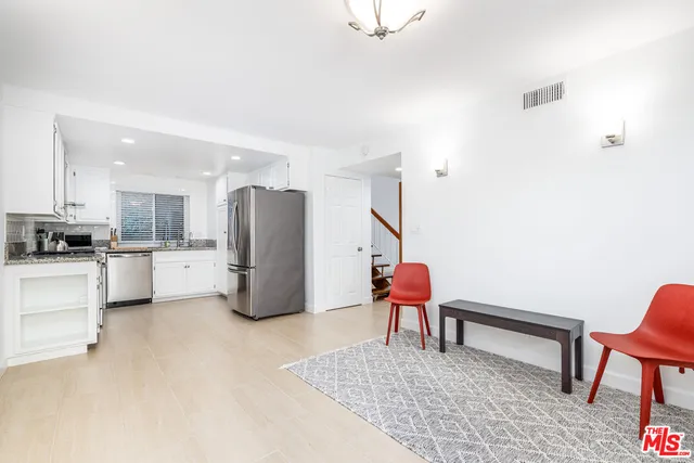 a living room with furniture and kitchen view