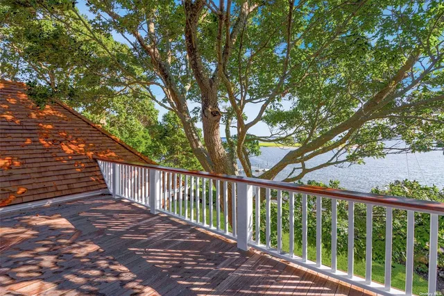 a balcony with wooden floor and trees