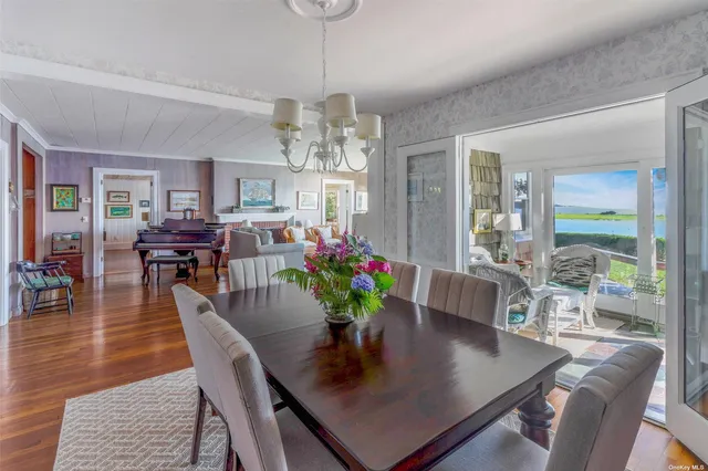 a view of a dining room with furniture a chandelier and wooden floor