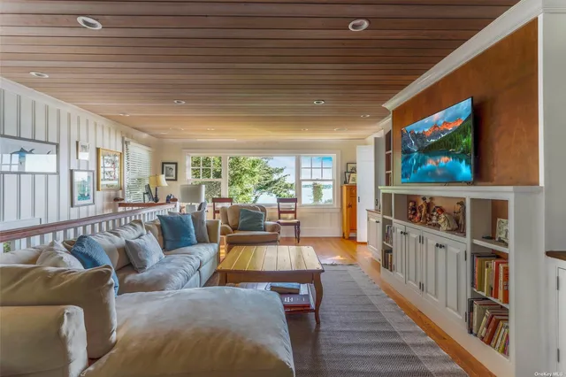 a living room with furniture wooden floor and a flat screen tv