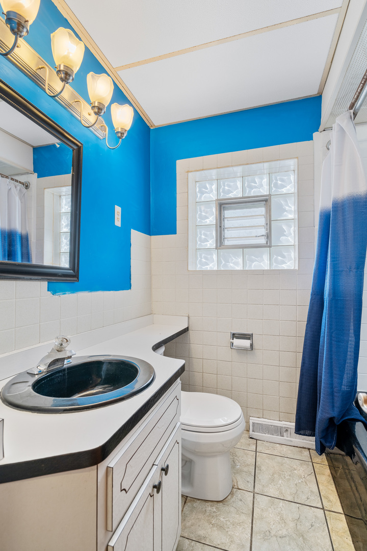7845 45th Street Lyons, IL 60534 - Photo 6 of 31 a bathroom with a sink a toilet and mirror