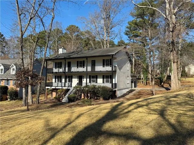 a view of a house with a yard and sitting area
