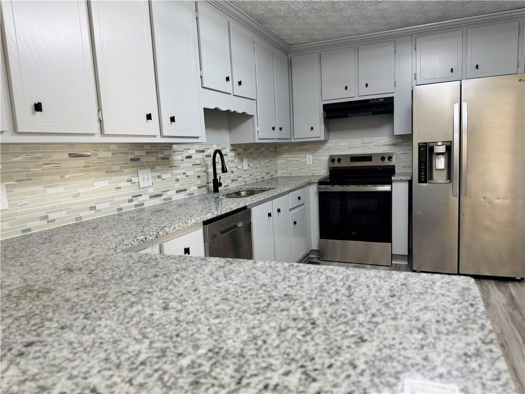 4795 Boxwood Way Northwest Acworth, GA 30102 - Photo 23 of 64 a kitchen with stainless steel appliances granite countertop a refrigerator sink and cabinets