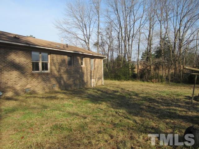 9276 Dirgie Mine Road Roxboro, NC 27574 - Photo 3 of 14 a backyard of a house with large trees