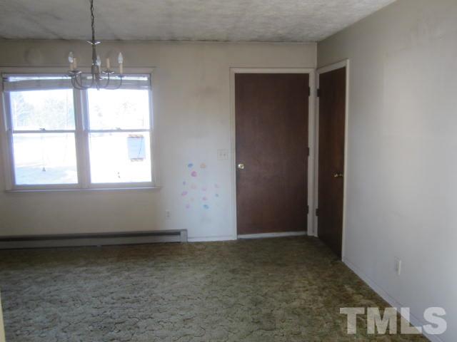 9276 Dirgie Mine Road Roxboro, NC 27574 - Photo 6 of 14 an empty room with chandelier fan and windows
