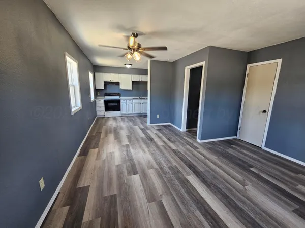 a view of a livingroom with wooden floor and staircase