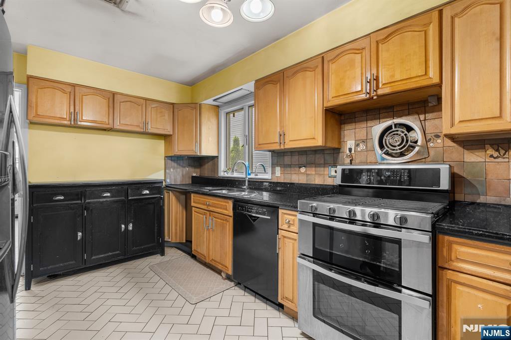 8 Hampton Road Clifton, NJ 07012 - Photo 8 of 16 a kitchen with stainless steel appliances granite countertop a stove and a refrigerator