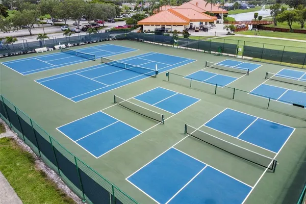 a view of a tennis ground with large trees