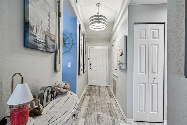 a view of a hallway with wooden floor and dining room