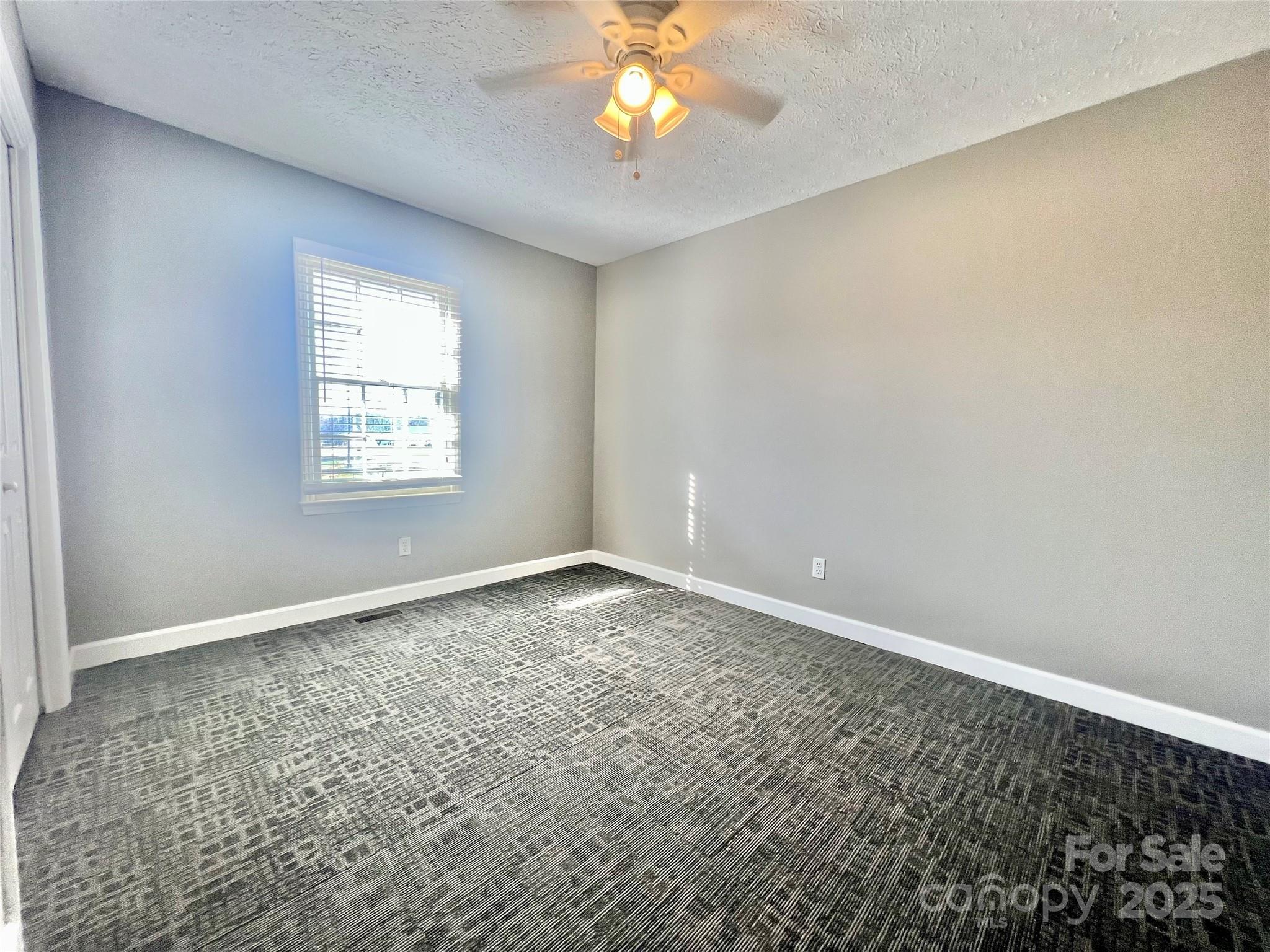 1182 Village Circle Hickory, NC 28602 - Photo 5 of 24 an empty room with windows and chandelier fan