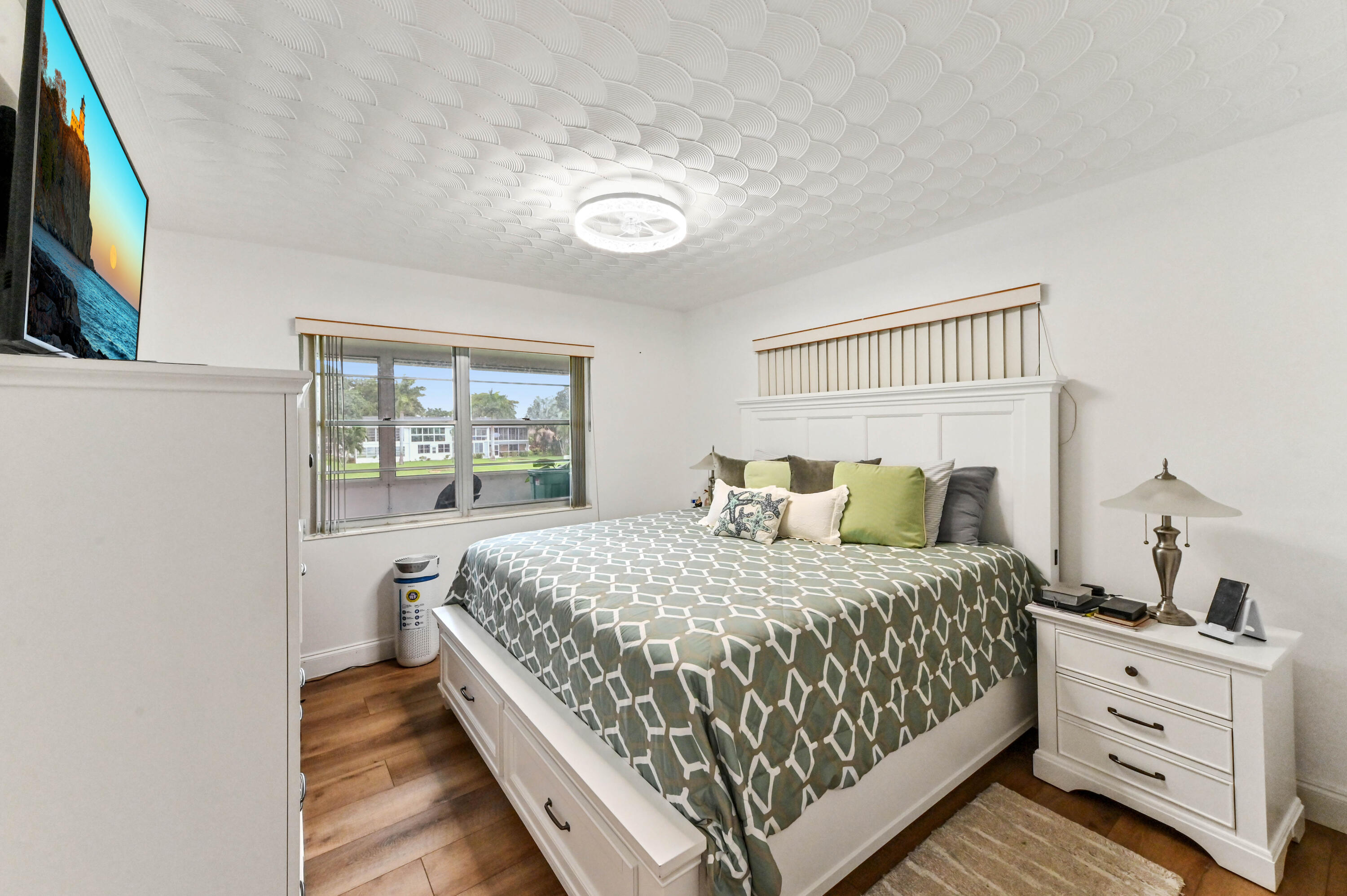 204 Ellesmere D Deerfield Beach, FL 33442 - Photo 7 of 46 a bedroom with a bed and a window