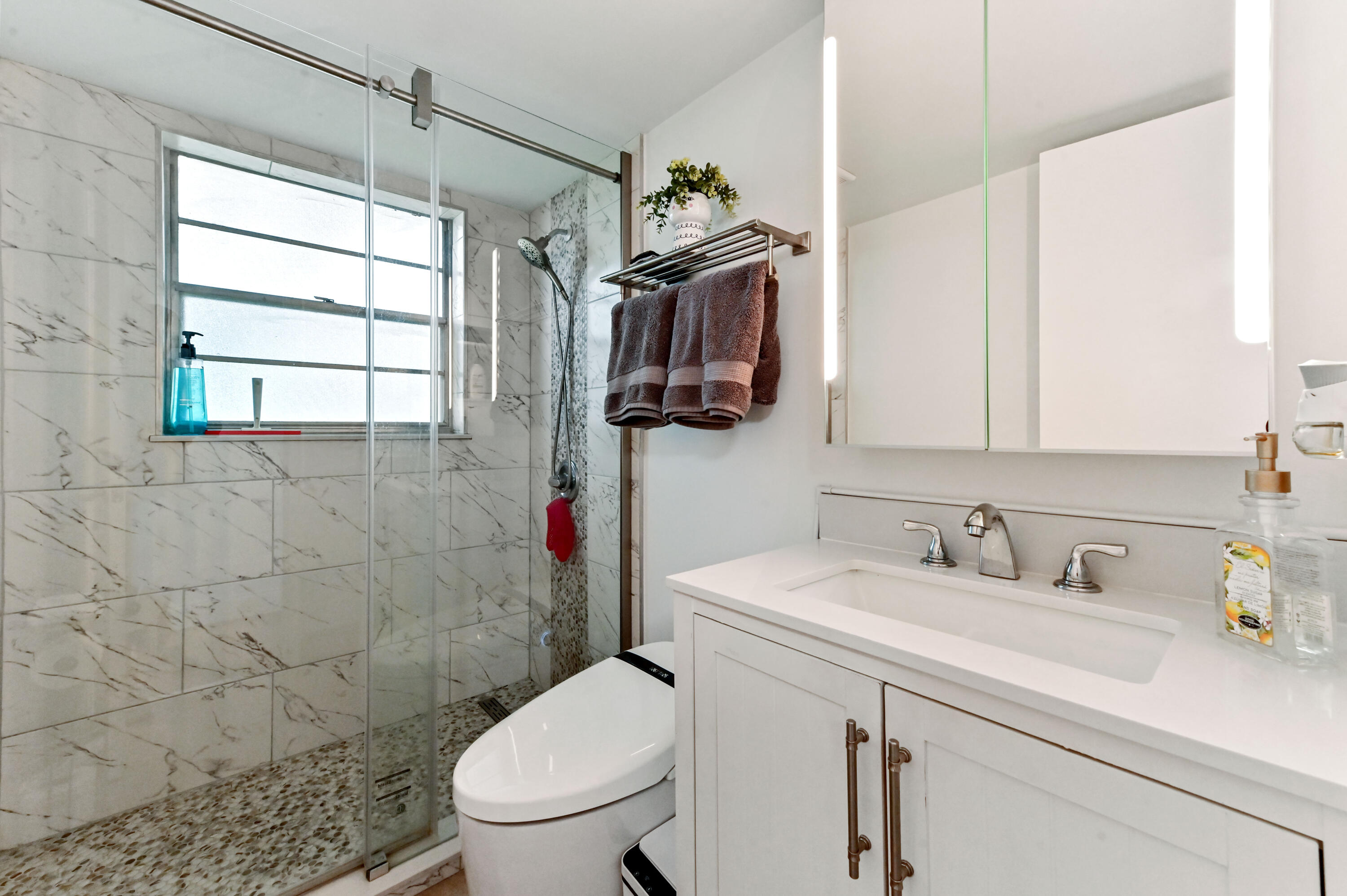 204 Ellesmere D Deerfield Beach, FL 33442 - Photo 8 of 46 a bathroom with a sink toilet and shower