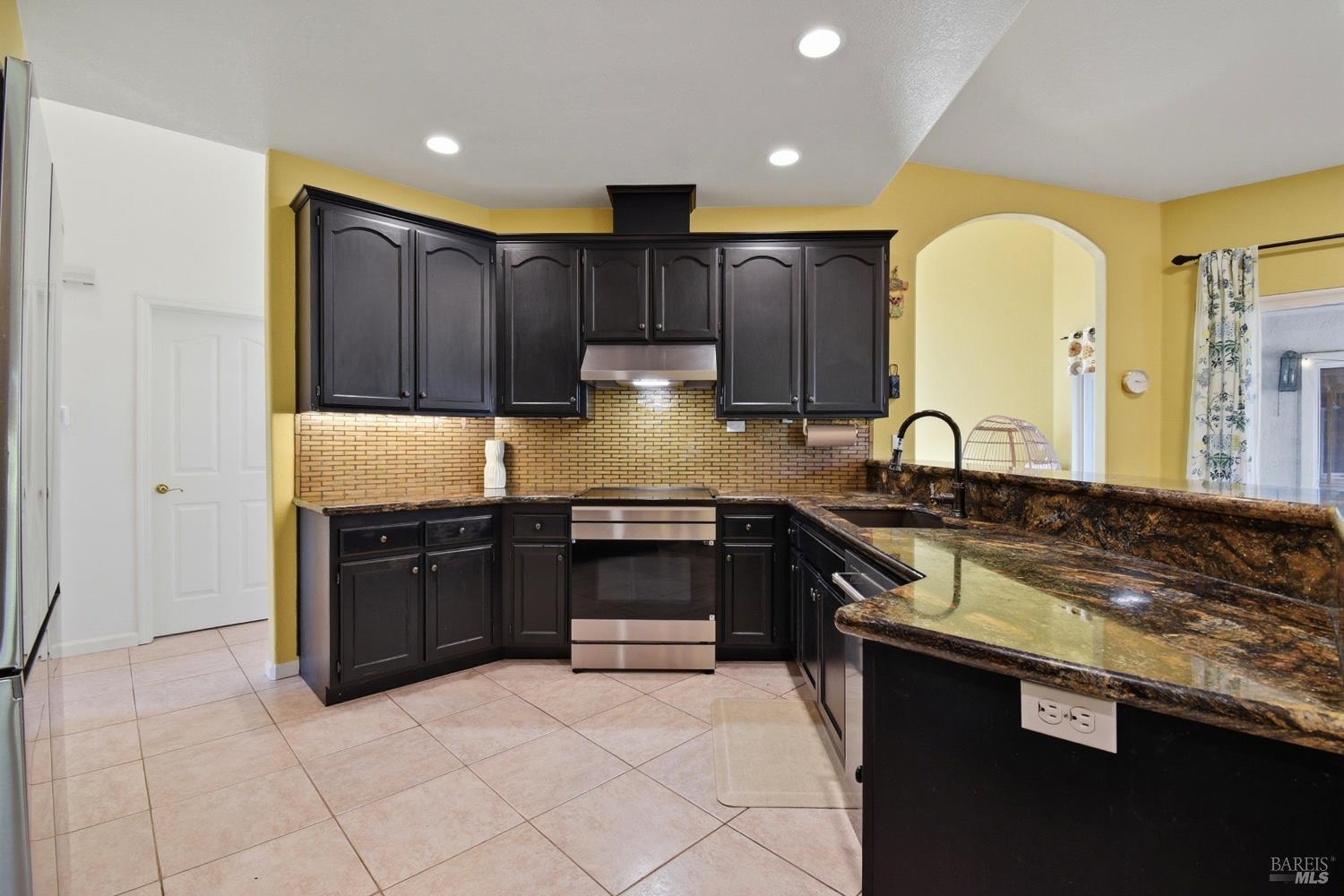 5828 Owl Hill Avenue Santa Rosa, CA 95409 - Photo 12 of 39 a kitchen with granite countertop a stove and cabinets