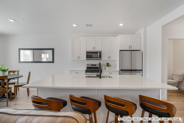 1702 Ripple Rock Drive, Unit 3171 Washington, UT 84780 - Photo 3 of 16 Spacious kitchen with a large central island, white cabinetry, stainless steel appliances, and a matte black faucet