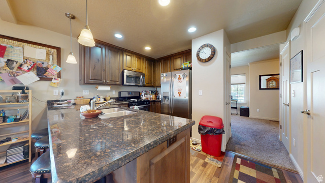 1674 Eastridge Road Price, UT 84501 - Photo 8 of 34 Kitchen featuring a breakfast bar with stone-finish countertop, wood-finish cabinetry, stainless steel appliances, and recessed lighting