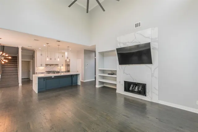 a living room with stainless steel appliances a flat screen tv and a refrigerator