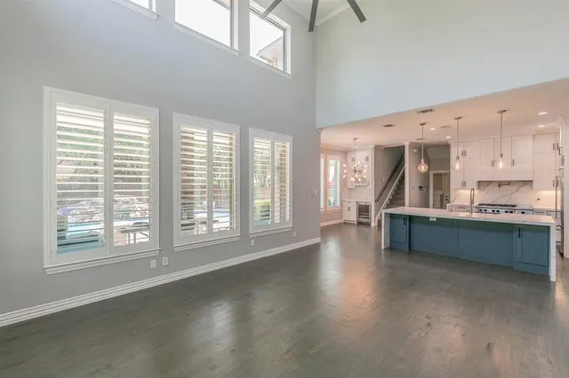 a kitchen with stainless steel appliances wooden floor and a large window