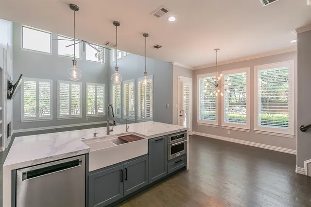 a bathroom with a sink a large window and a chandelier