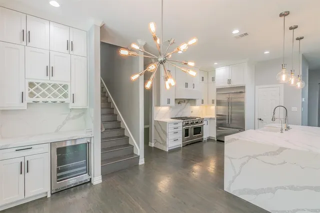 a kitchen with stainless steel appliances kitchen island a refrigerator sink and cabinets