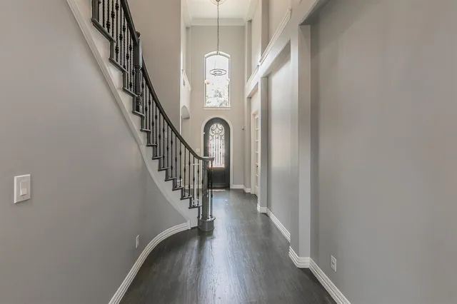 a view of staircase with wooden floor and white walls