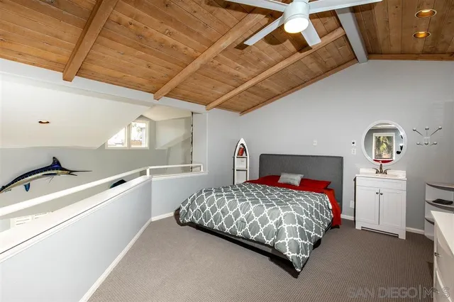 a bedroom with a bed next to a window with a chandelier