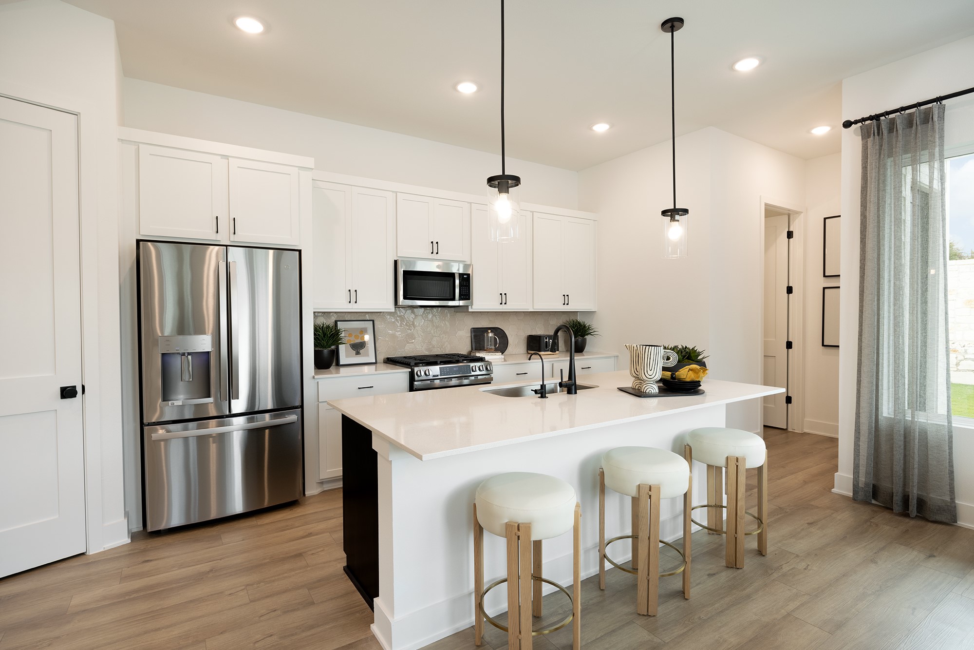 1306 Sweet Bark Street Austin, TX 78745 - Photo 2 of 12 a kitchen with stainless steel appliances granite countertop a refrigerator a stove a sink a dining table and chairs with wooden floor