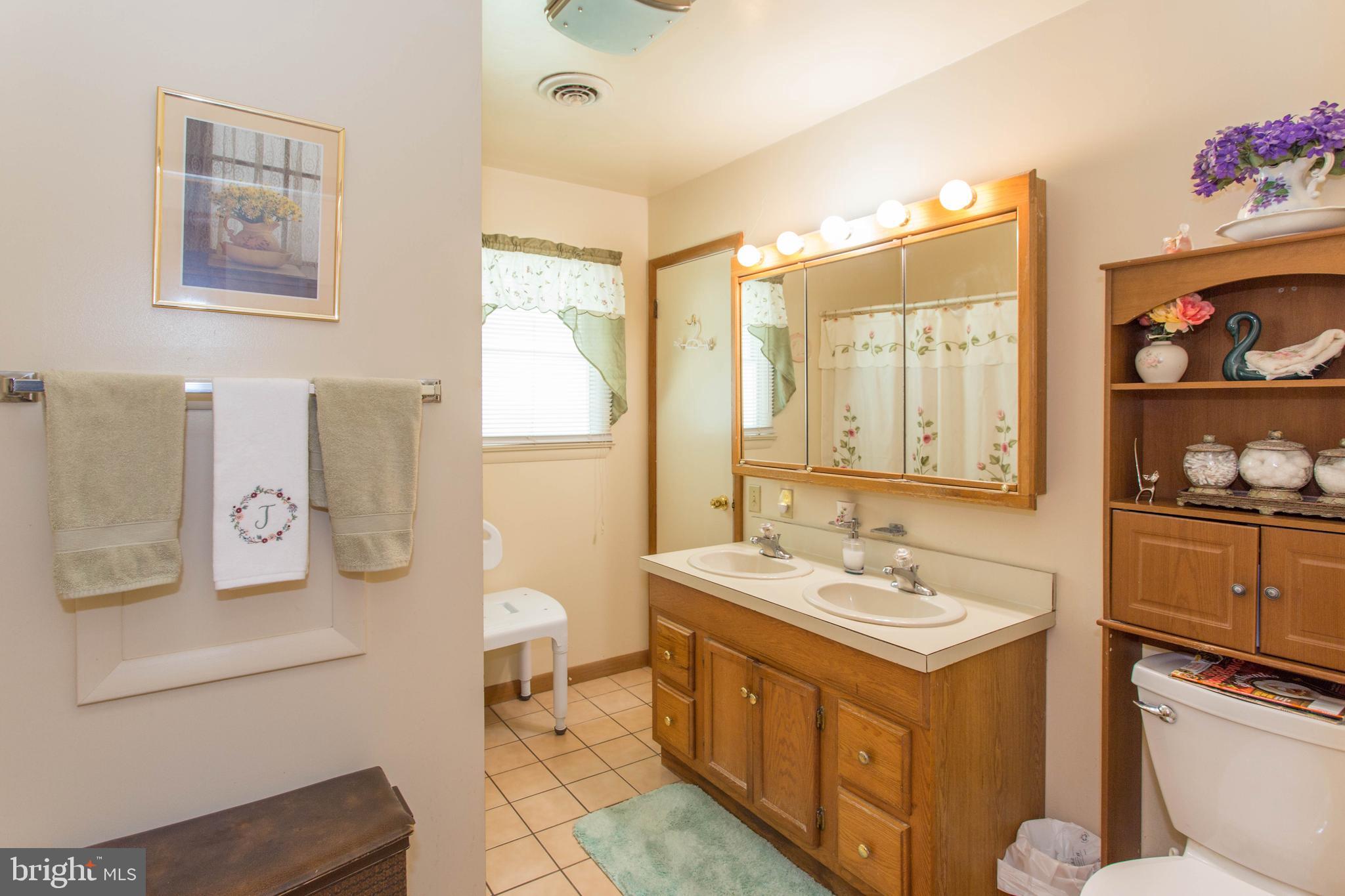22167 Melson Road Georgetown, DE 19947 - Photo 24 of 38 a spacious bathroom with a sink mirror vanity and toilet