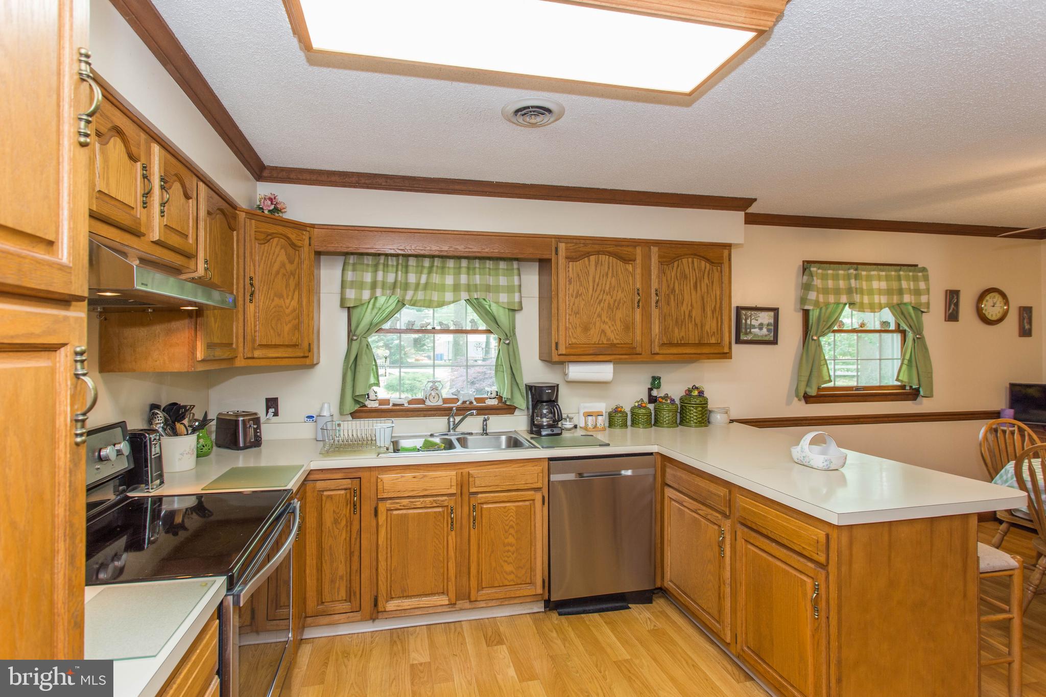 22167 Melson Road Georgetown, DE 19947 - Photo 3 of 38 a kitchen with a sink a stove cabinets and a wooden floor