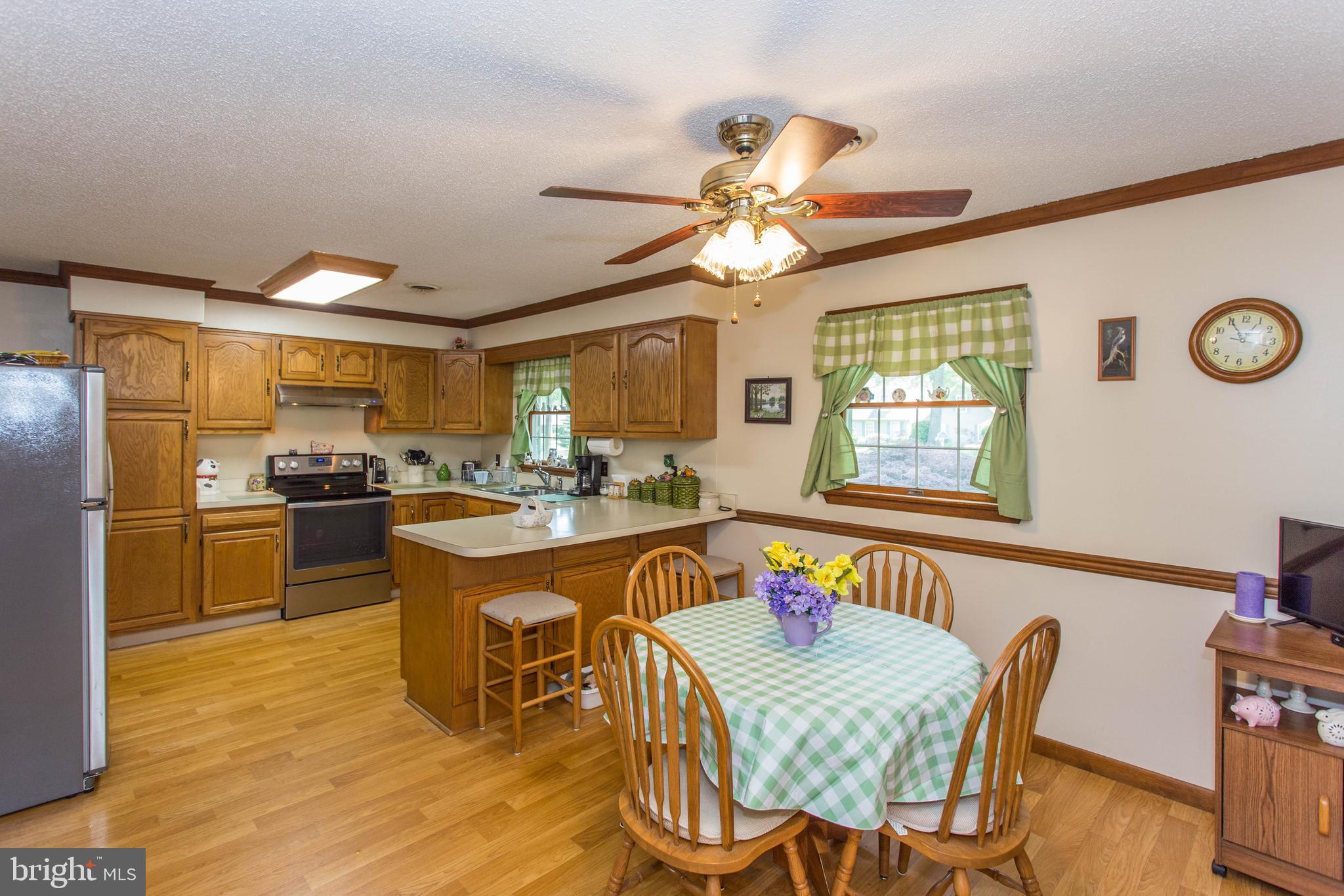22167 Melson Road Georgetown, DE 19947 - Photo 4 of 38 a view of a dining room with furniture a chandelier and wooden floor