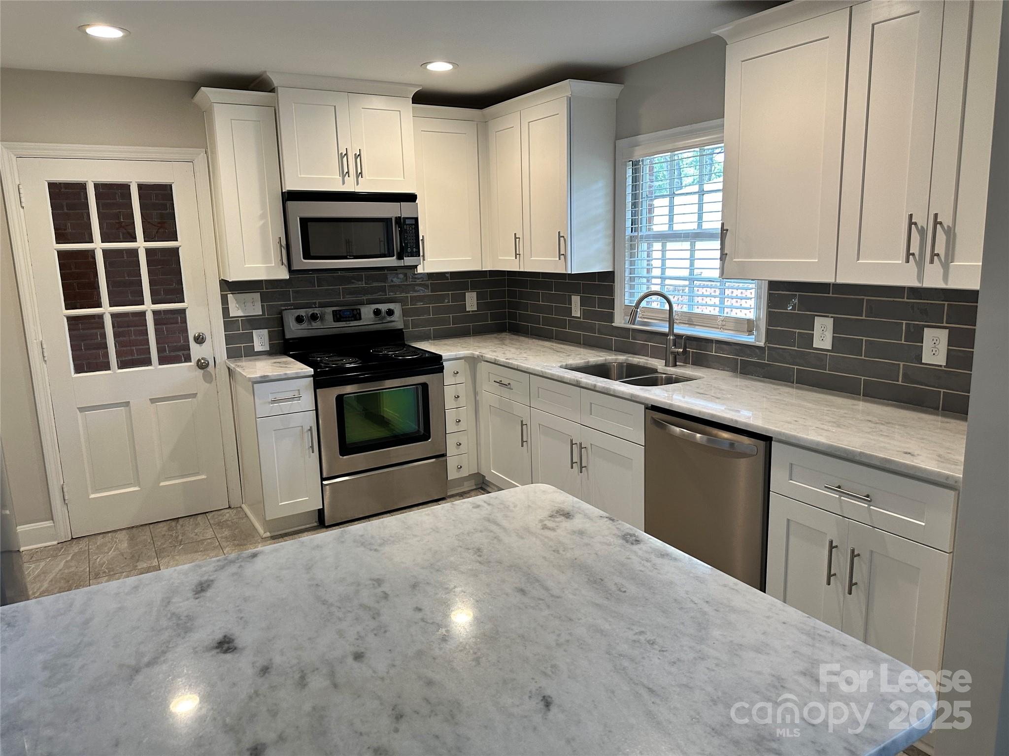 2518 Westfield Road Charlotte, NC 28209 - Photo 8 of 19 a kitchen with stainless steel appliances granite countertop a stove a sink and a microwave