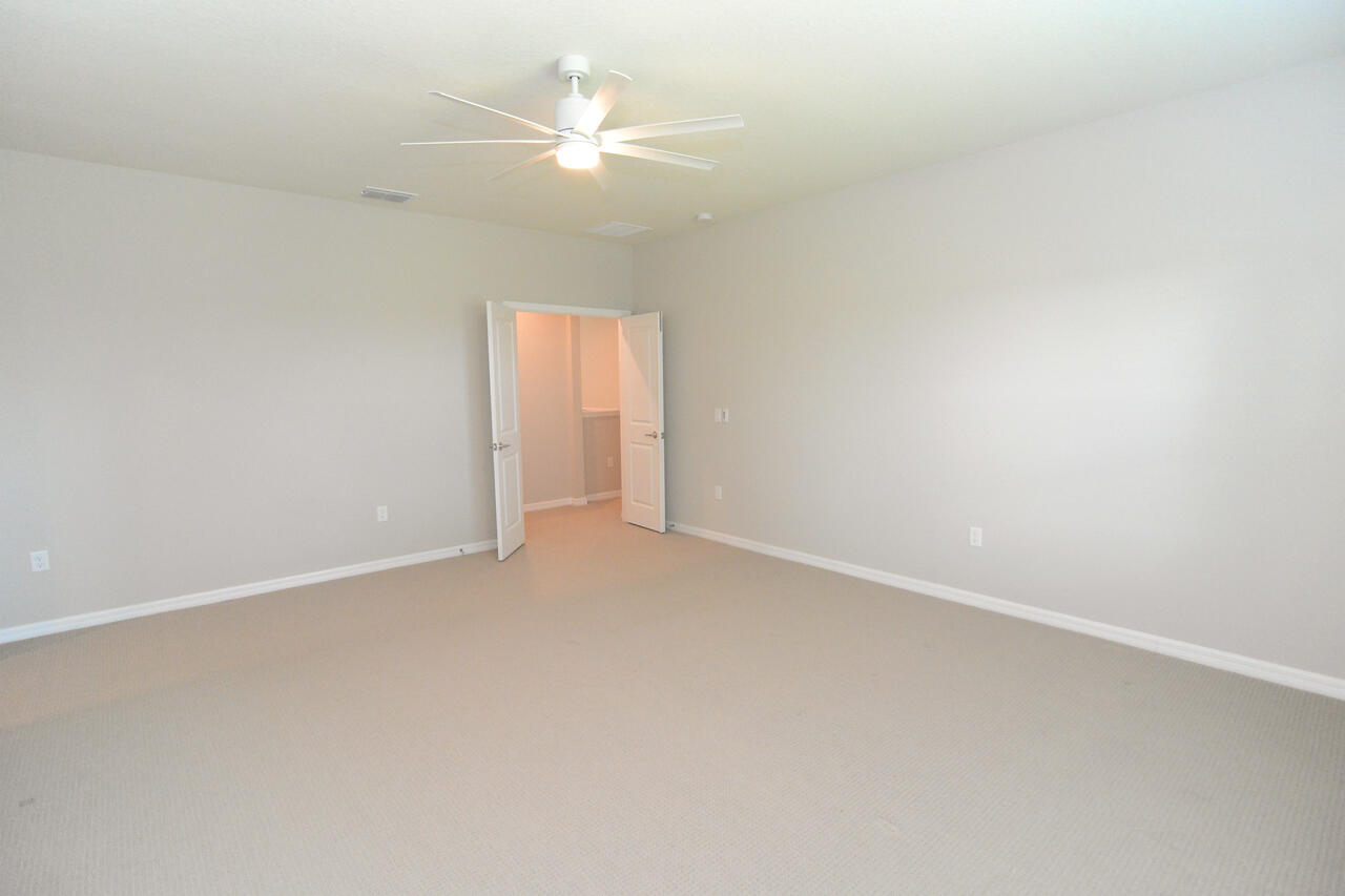902 Foal Point Oviedo, FL 32765 - Photo 24 of 35 an empty room with a chandelier fan and windows