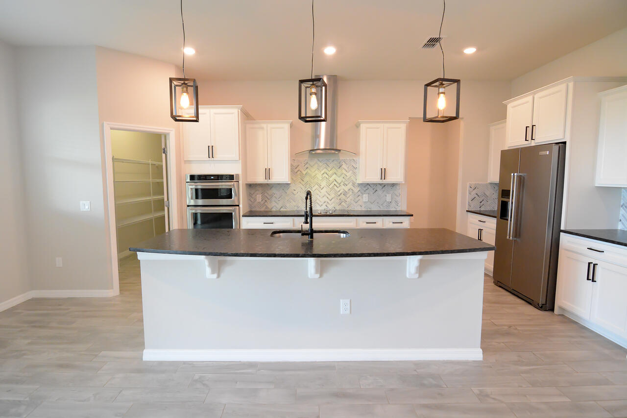 902 Foal Point Oviedo, FL 32765 - Photo 10 of 35 a large kitchen with stainless steel appliances kitchen island granite countertop a refrigerator a oven and a sink
