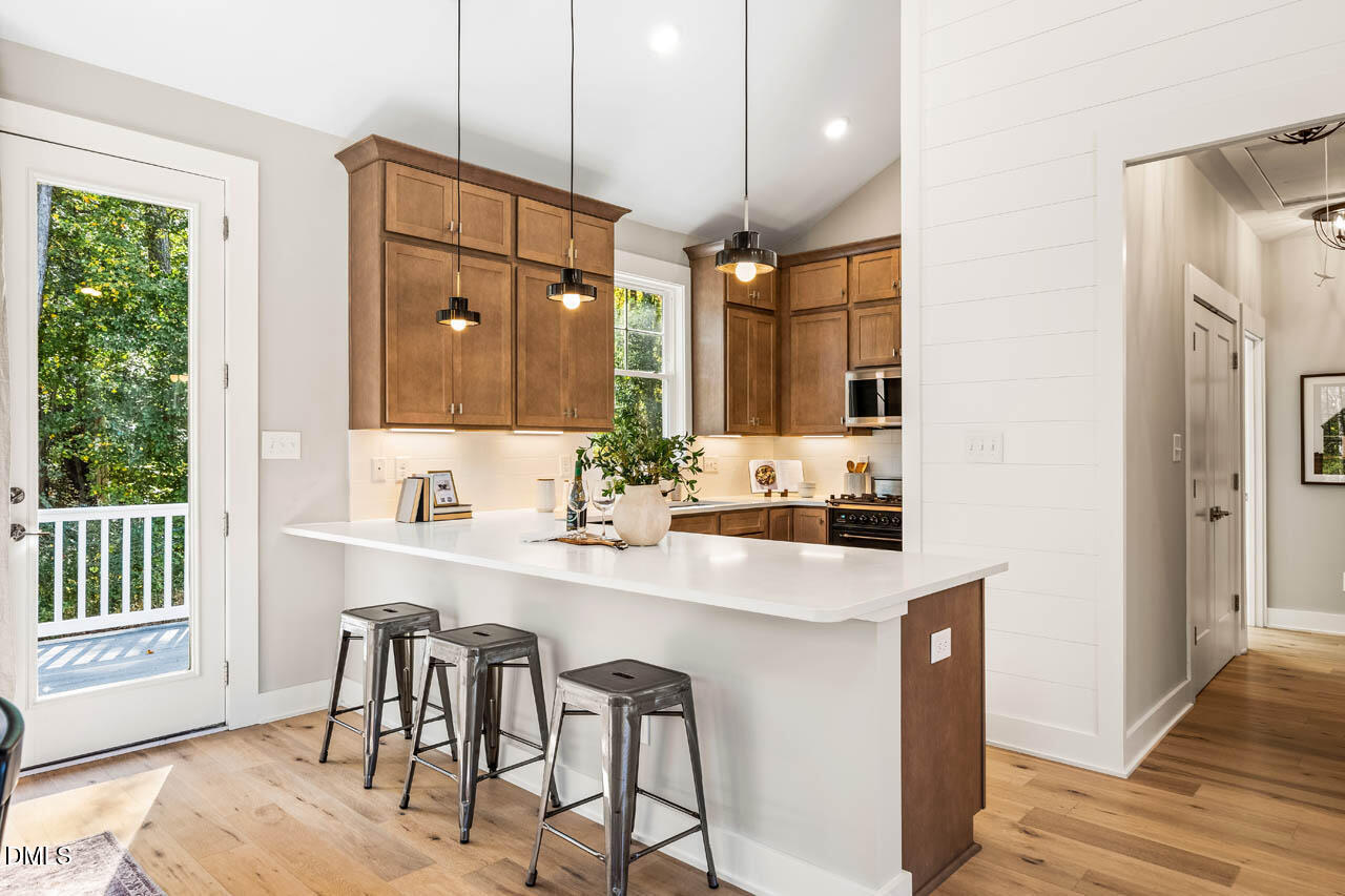 1905 Milan Street Durham, NC 27704 - Photo 11 of 42 a kitchen with kitchen island a sink stove and wooden floor