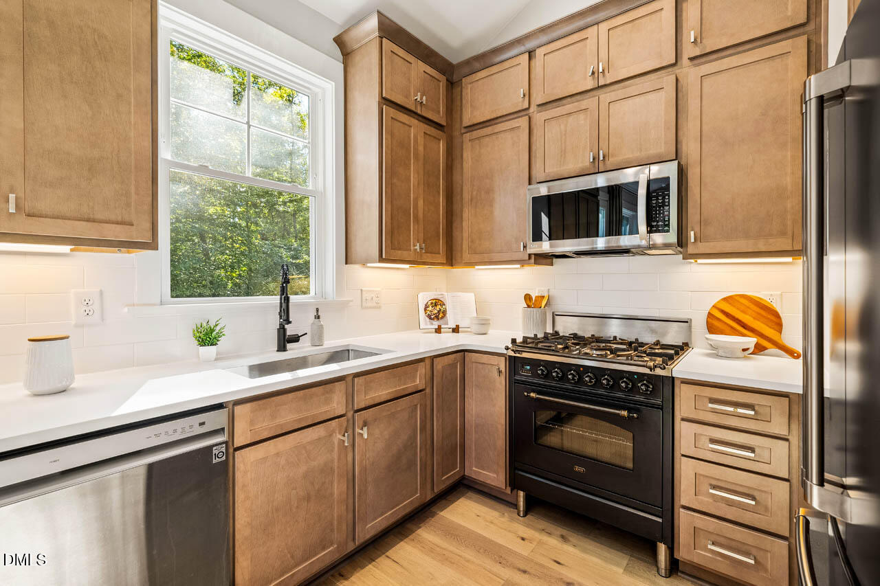1905 Milan Street Durham, NC 27704 - Photo 13 of 42 a kitchen with stainless steel appliances a stove sink and cabinets