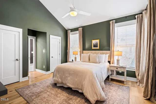 a view of a hallway with wooden floor and a bathroom