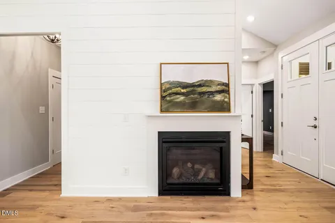a living room with furniture a fireplace and a large window with wooden floor