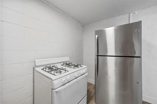 a kitchen with a refrigerator and a stove top oven