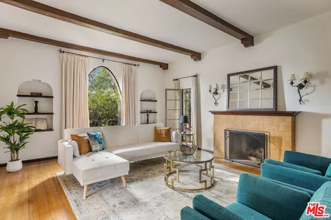 a living room with furniture fireplace and a large window
