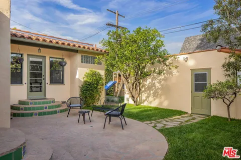 a view of a house with backyard sitting area and garden