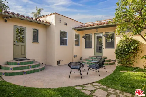 a view of a house with backyard and sitting area