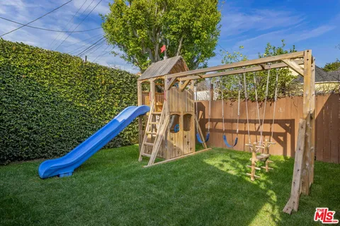 a view of a backyard with a wooden fence and a bench