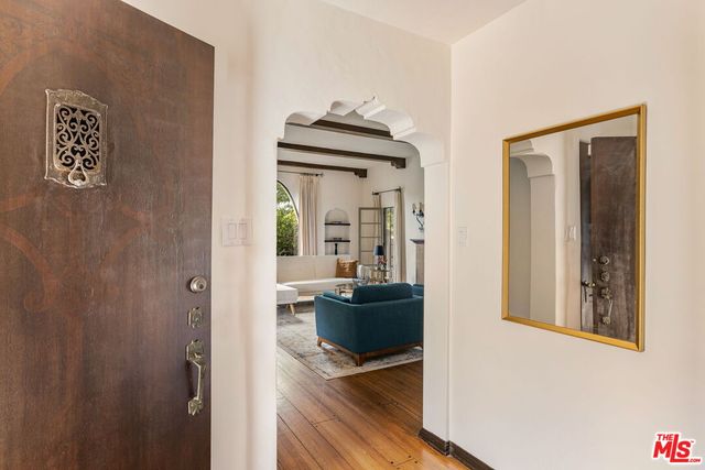 a hallway with a door and wooden floor